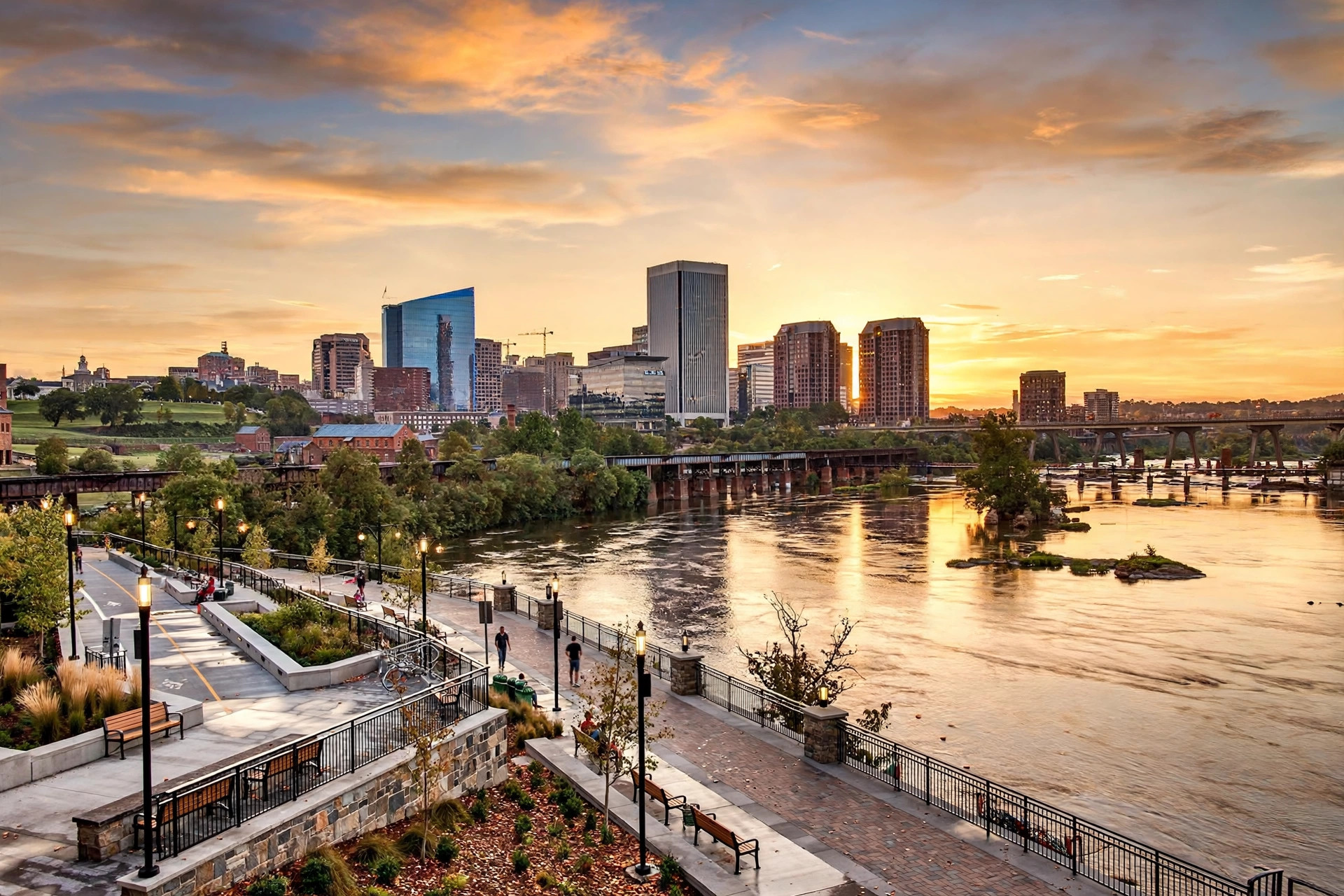 Richmond, Virginia downtown skyline along the James River at golden hour, with historic brick buildings and modern office towers
